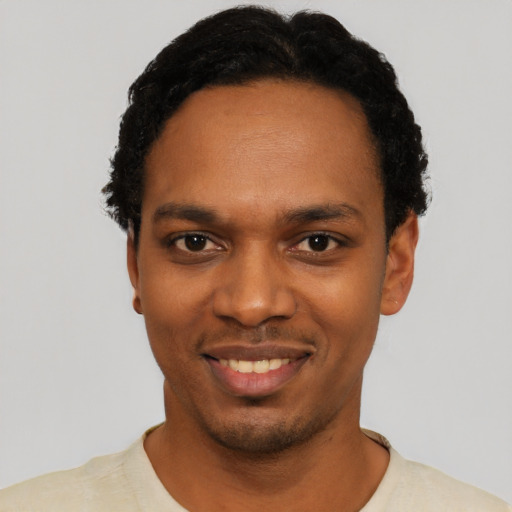 Joyful black young-adult male with short  black hair and brown eyes