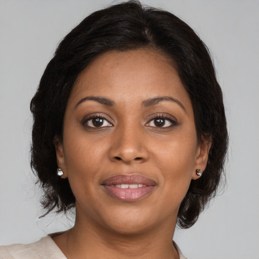 Joyful black young-adult female with medium  brown hair and brown eyes