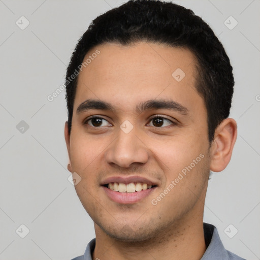 Joyful latino young-adult male with short  black hair and brown eyes