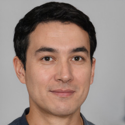 Joyful white young-adult male with short  black hair and brown eyes