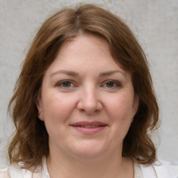 Joyful white young-adult female with medium  brown hair and grey eyes