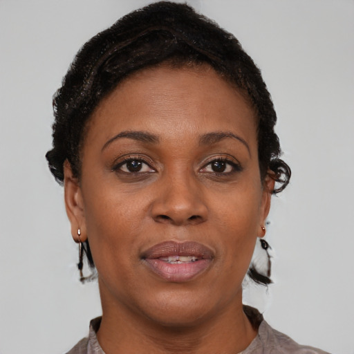Joyful black adult female with short  brown hair and brown eyes