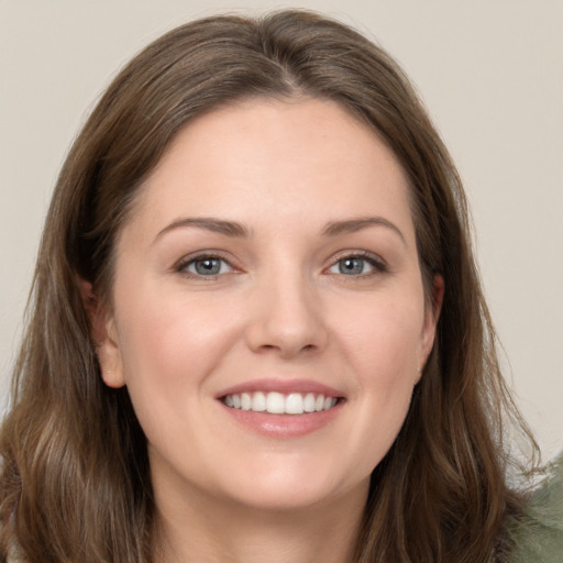 Joyful white young-adult female with long  brown hair and grey eyes