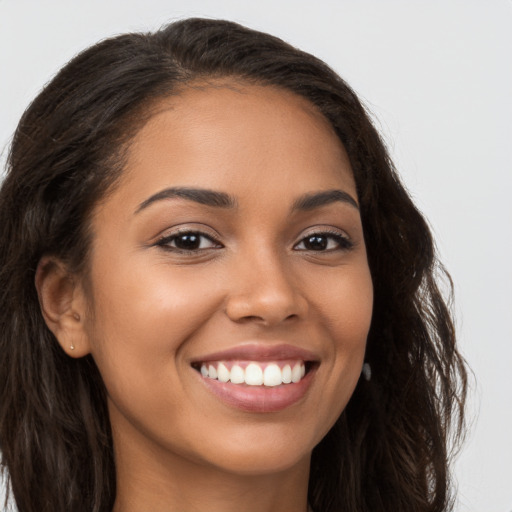 Joyful latino young-adult female with long  brown hair and brown eyes