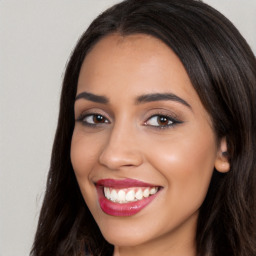 Joyful latino young-adult female with long  brown hair and brown eyes