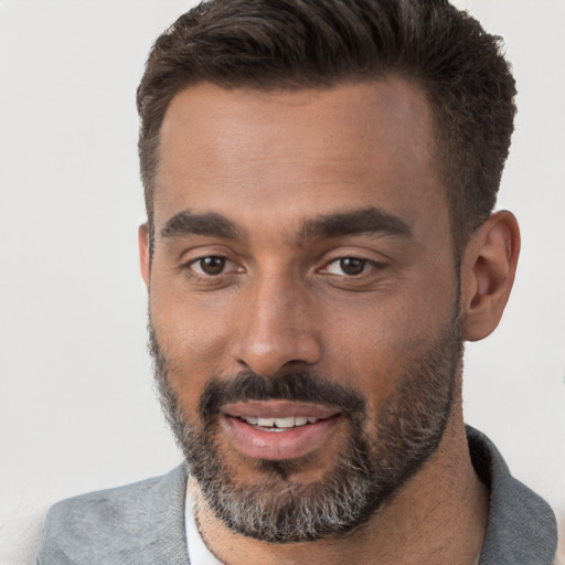 Joyful black young-adult male with short  brown hair and brown eyes