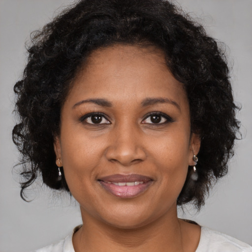 Joyful black adult female with medium  brown hair and brown eyes