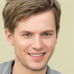 Joyful white young-adult male with short  brown hair and grey eyes