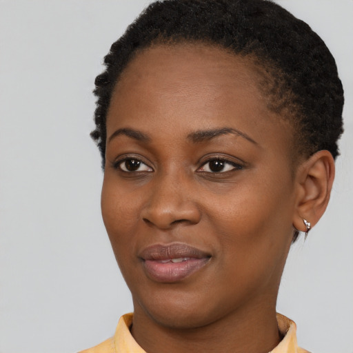 Joyful black young-adult female with short  black hair and brown eyes