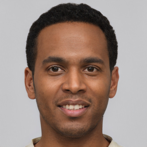 Joyful black young-adult male with short  black hair and brown eyes
