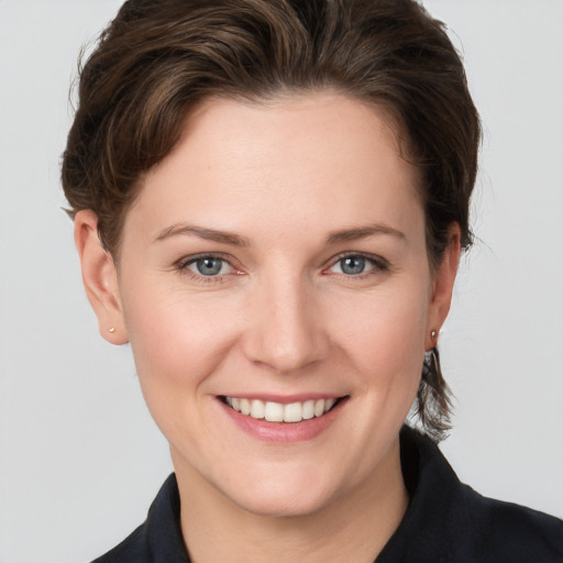 Joyful white young-adult female with short  brown hair and grey eyes