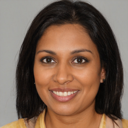 Joyful black young-adult female with medium  brown hair and brown eyes