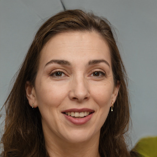 Joyful white adult female with long  brown hair and brown eyes