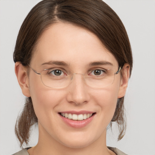 Joyful white young-adult female with medium  brown hair and grey eyes