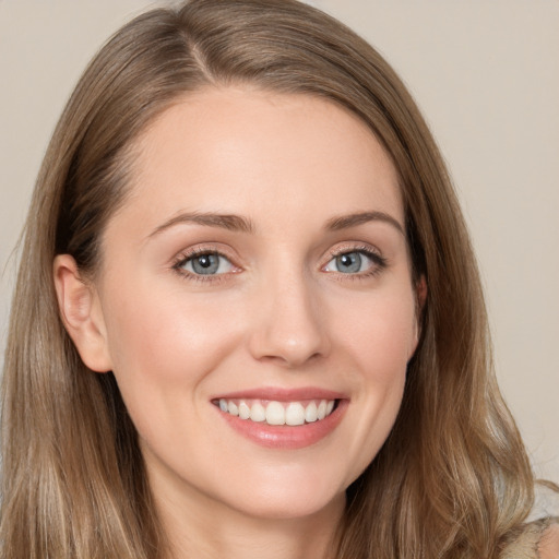 Joyful white young-adult female with long  brown hair and grey eyes