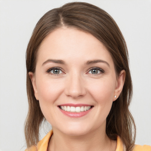 Joyful white young-adult female with medium  brown hair and grey eyes