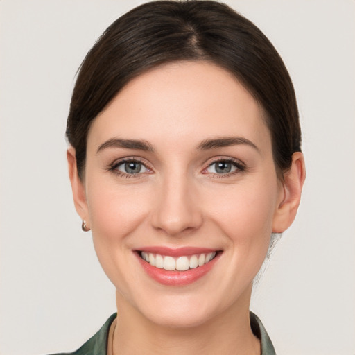 Joyful white young-adult female with medium  brown hair and grey eyes