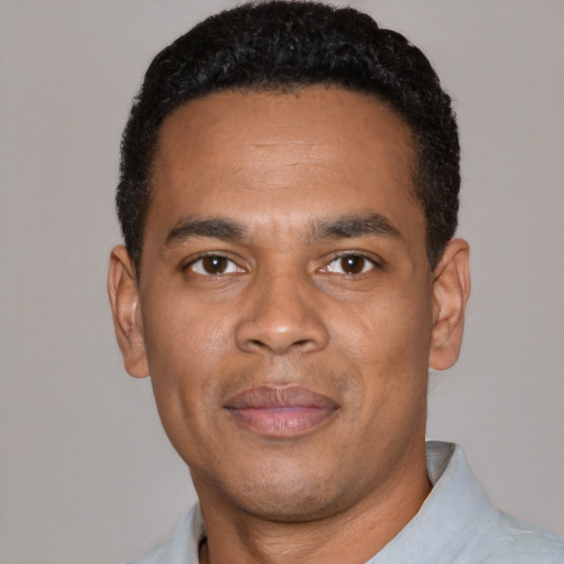 Joyful black young-adult male with short  black hair and brown eyes
