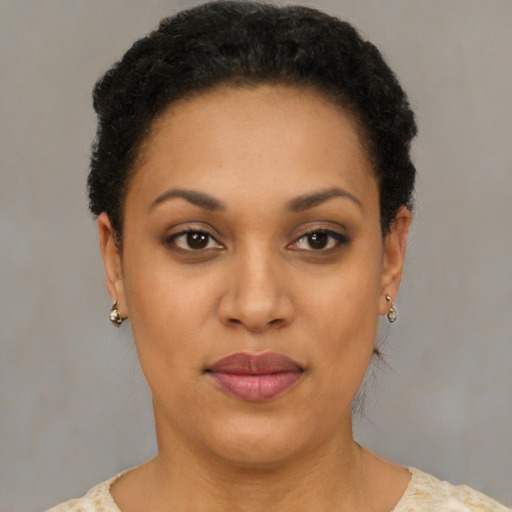 Joyful black young-adult female with short  black hair and brown eyes