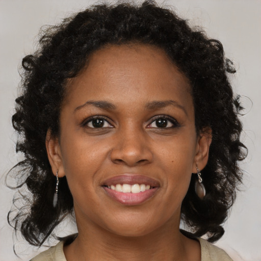 Joyful black young-adult female with medium  brown hair and brown eyes