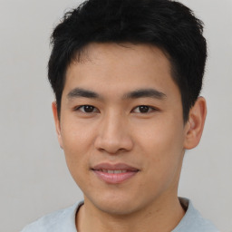 Joyful asian young-adult male with short  black hair and brown eyes