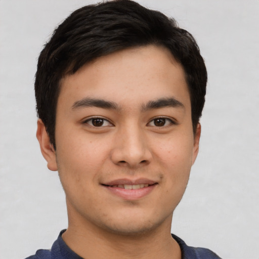 Joyful asian young-adult male with short  brown hair and brown eyes
