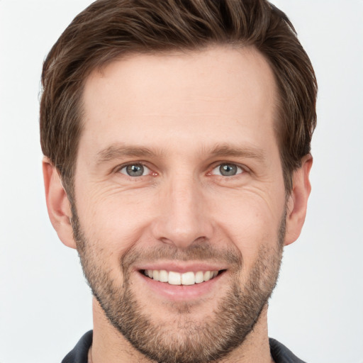 Joyful white young-adult male with short  brown hair and grey eyes