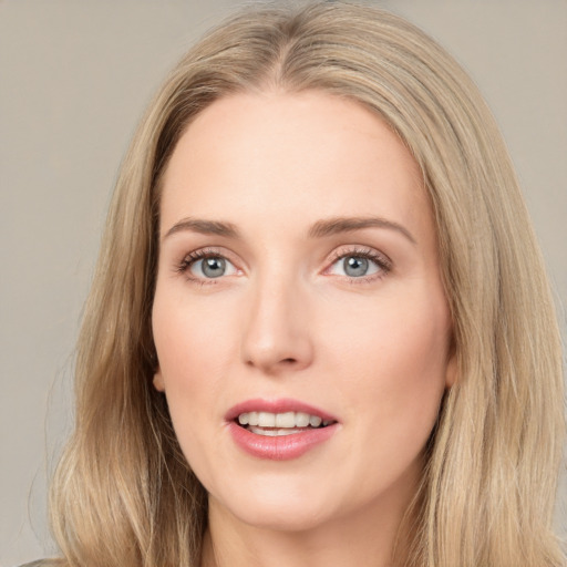 Joyful white young-adult female with long  brown hair and blue eyes