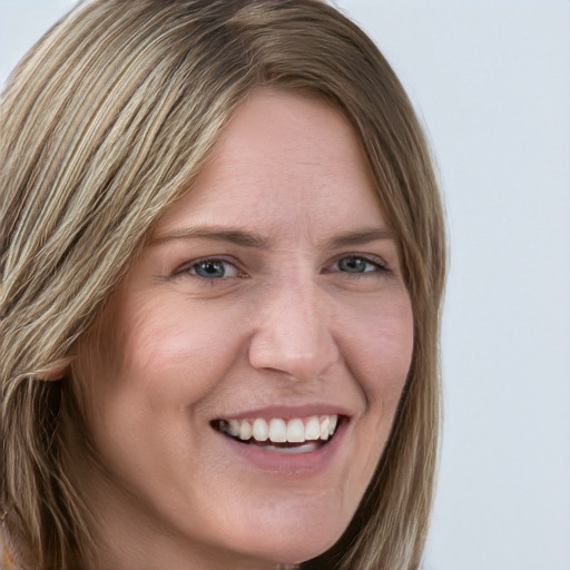 Joyful white young-adult female with long  brown hair and blue eyes