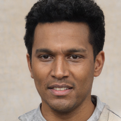 Joyful latino young-adult male with short  black hair and brown eyes
