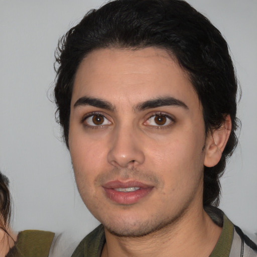 Joyful white young-adult male with medium  black hair and brown eyes