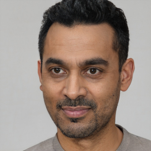 Joyful black adult male with short  black hair and brown eyes