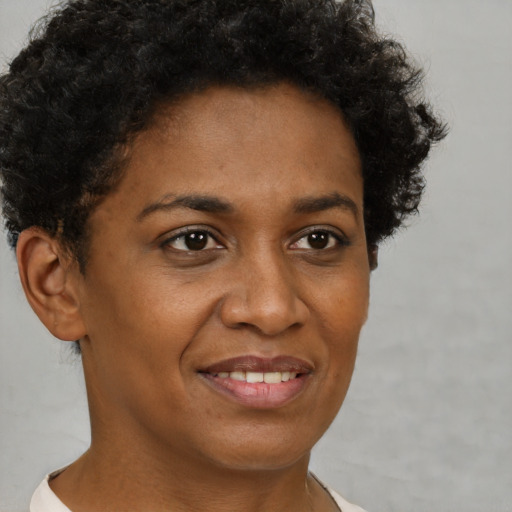 Joyful black young-adult female with short  brown hair and brown eyes