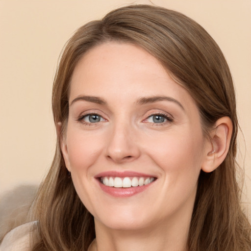 Joyful white young-adult female with long  brown hair and grey eyes