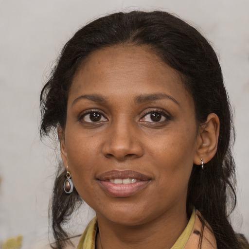 Joyful black adult female with medium  brown hair and brown eyes