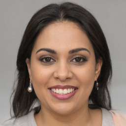 Joyful latino young-adult female with medium  brown hair and brown eyes