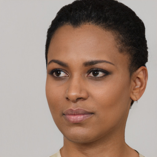 Joyful black young-adult female with short  black hair and brown eyes