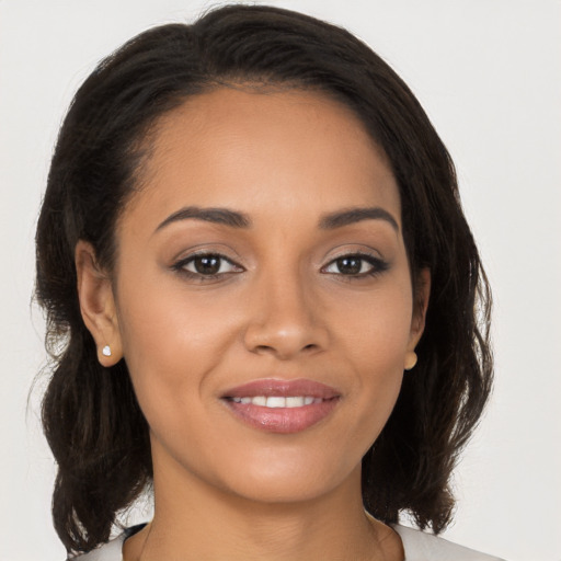 Joyful latino young-adult female with medium  brown hair and brown eyes