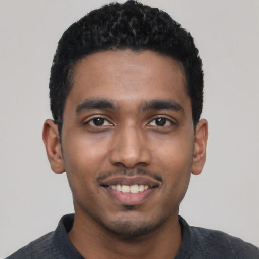 Joyful black young-adult male with short  black hair and brown eyes