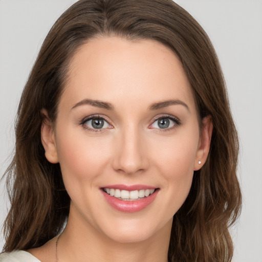 Joyful white young-adult female with long  brown hair and grey eyes