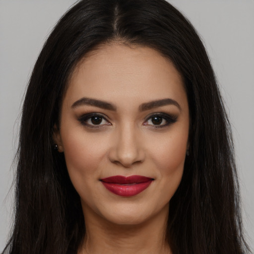 Joyful latino young-adult female with long  brown hair and brown eyes