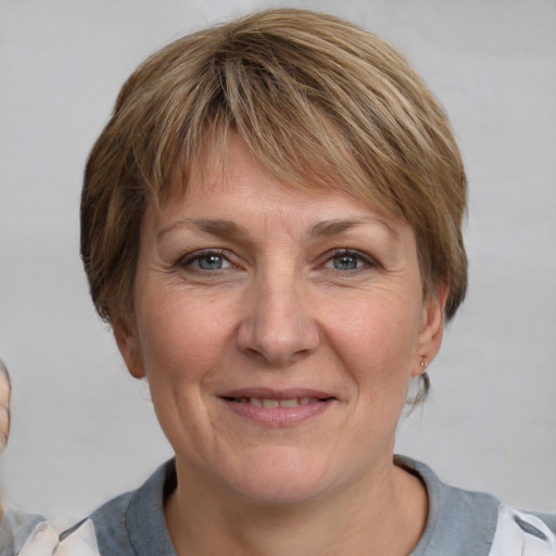 Joyful white adult female with medium  brown hair and grey eyes