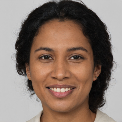 Joyful black adult female with medium  brown hair and brown eyes