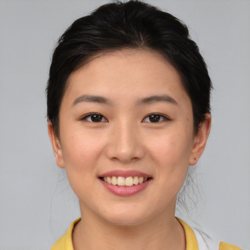 Joyful asian young-adult female with medium  brown hair and brown eyes