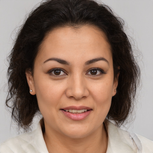Joyful latino young-adult female with medium  brown hair and brown eyes