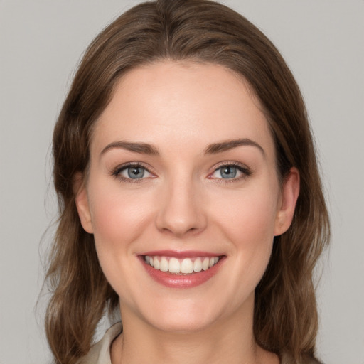 Joyful white young-adult female with medium  brown hair and grey eyes