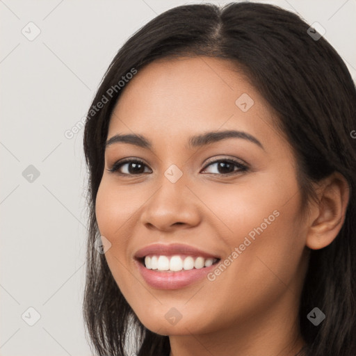 Joyful latino young-adult female with long  black hair and brown eyes