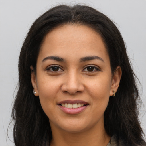 Joyful latino young-adult female with long  brown hair and brown eyes