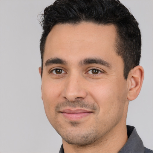 Joyful white young-adult male with short  black hair and brown eyes