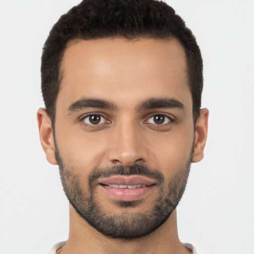 Joyful latino young-adult male with short  black hair and brown eyes